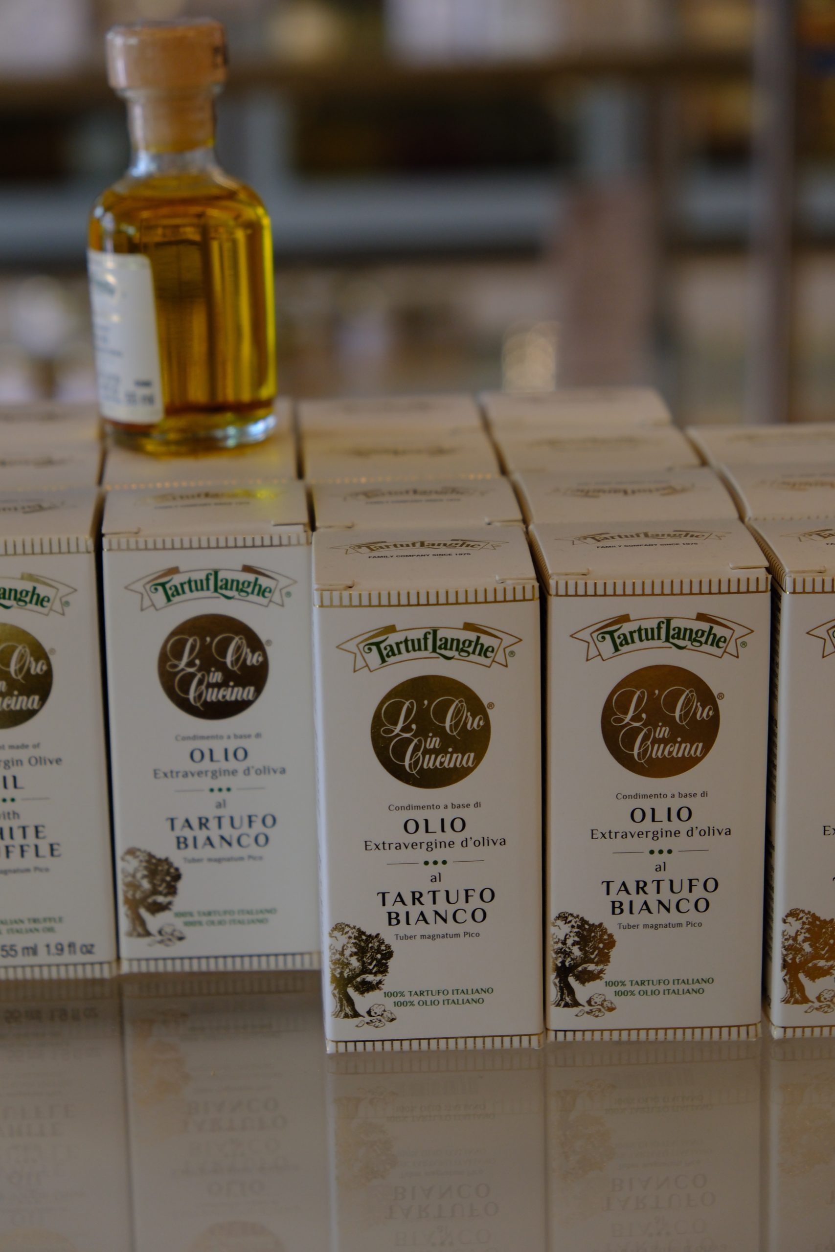 Bottles of TartufLanghe truffle oil displayed beside their boxes.