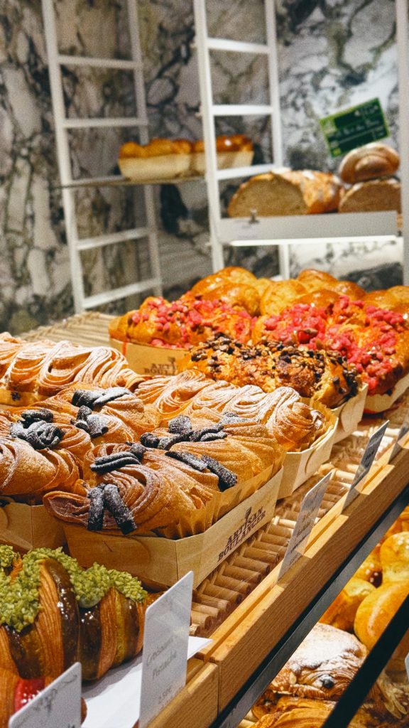Display of croissants and colorful laminated pastries inside a bakery in Maisons-Laffitte.