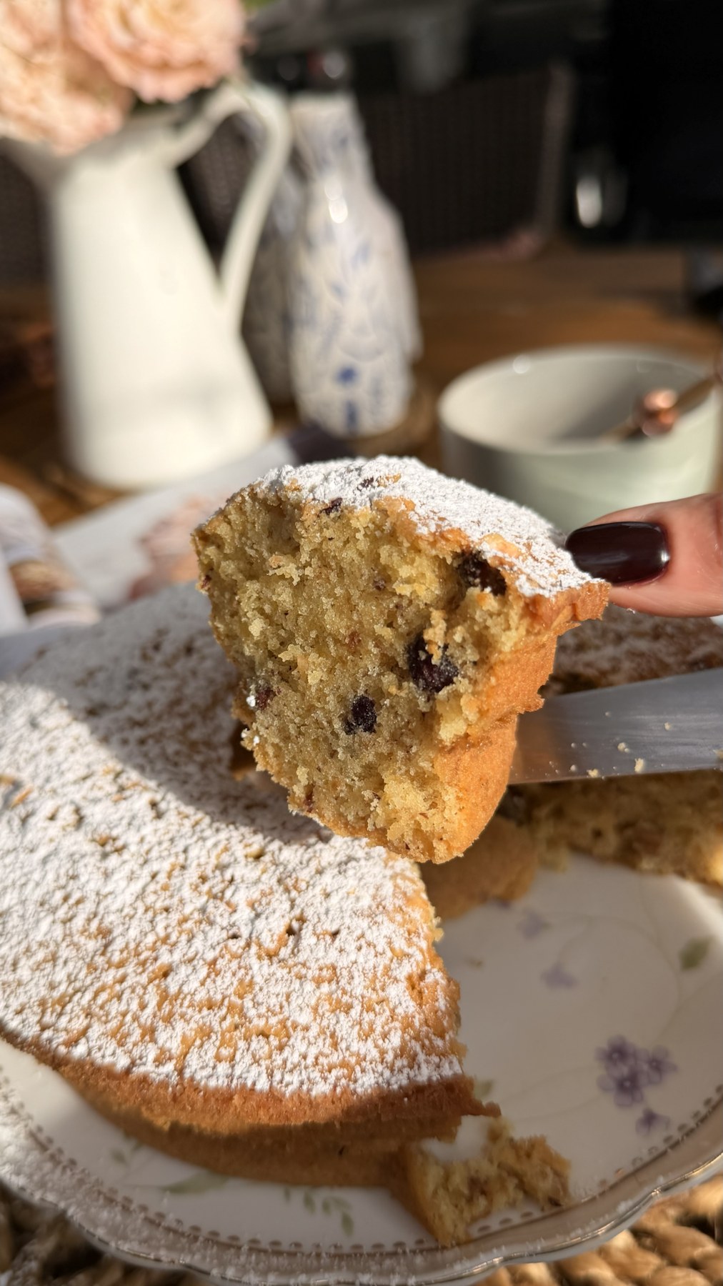 A freshly cut slice revealing the moist crumb and chopped hazelnuts inside the finished cake.