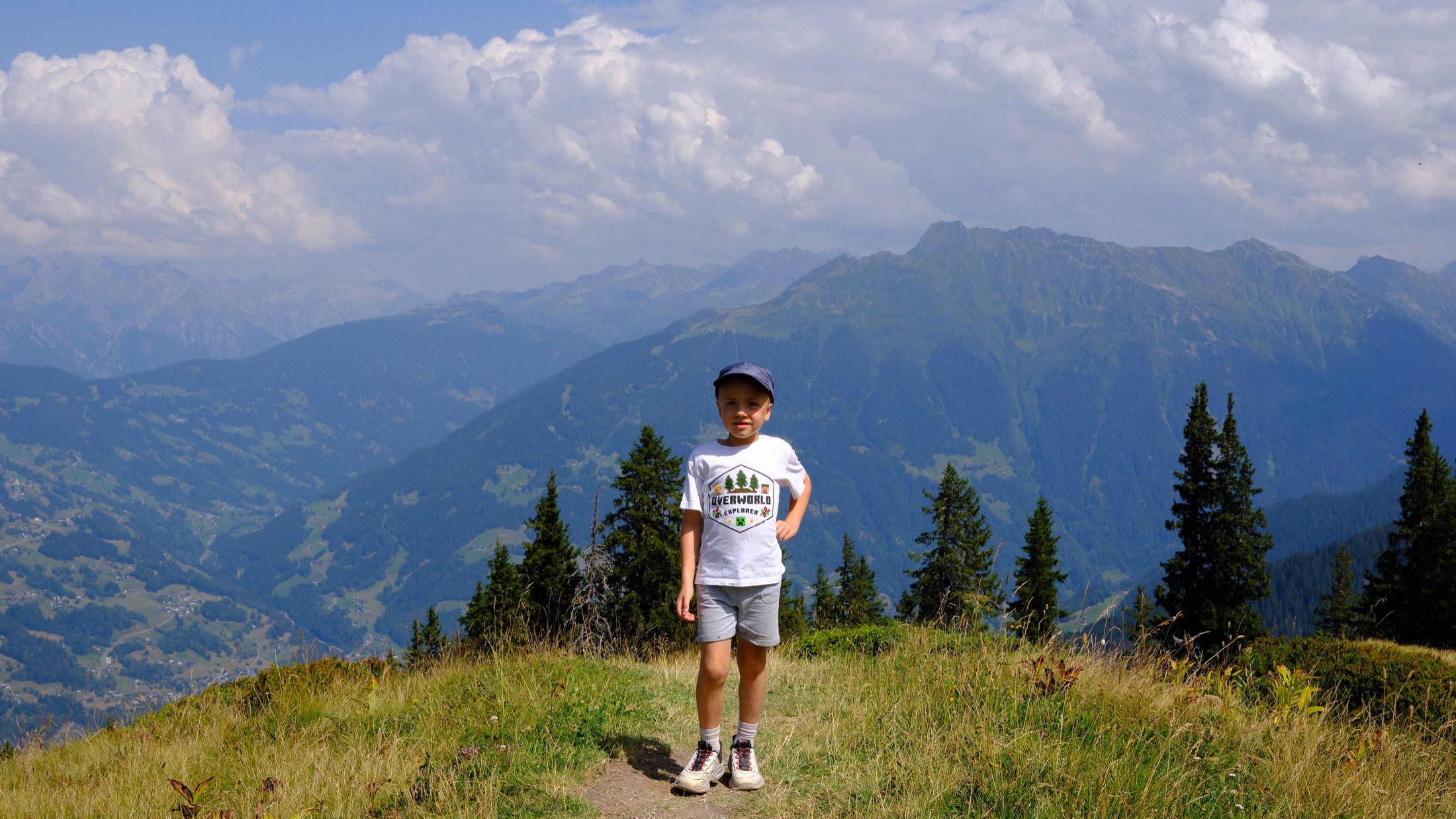 A child standing before the layered mountains of the Montafon valley