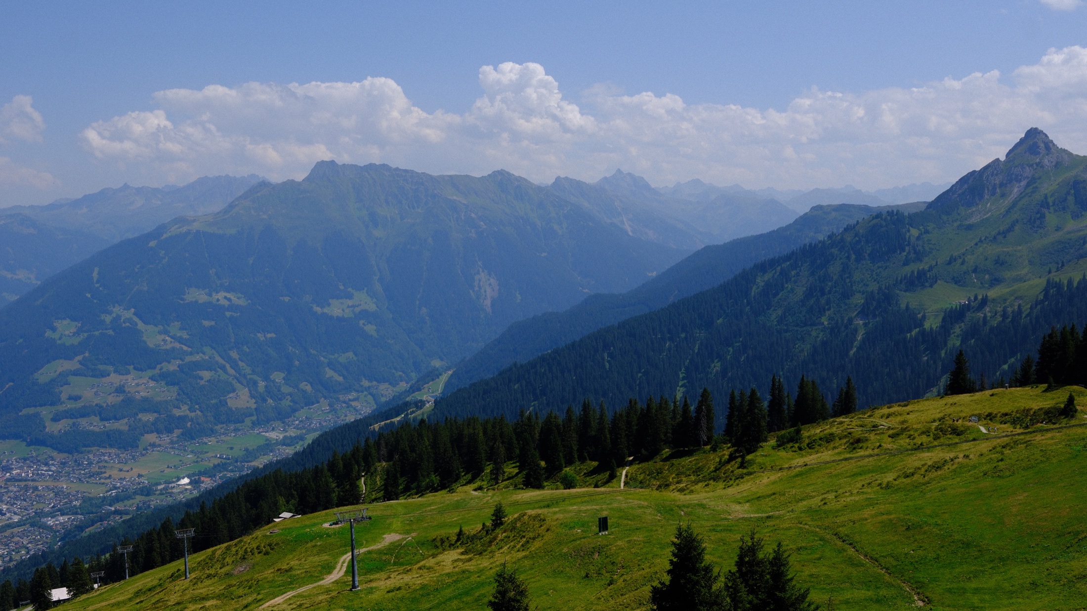 Layered Alpine mountains and green slopes seen from Golm