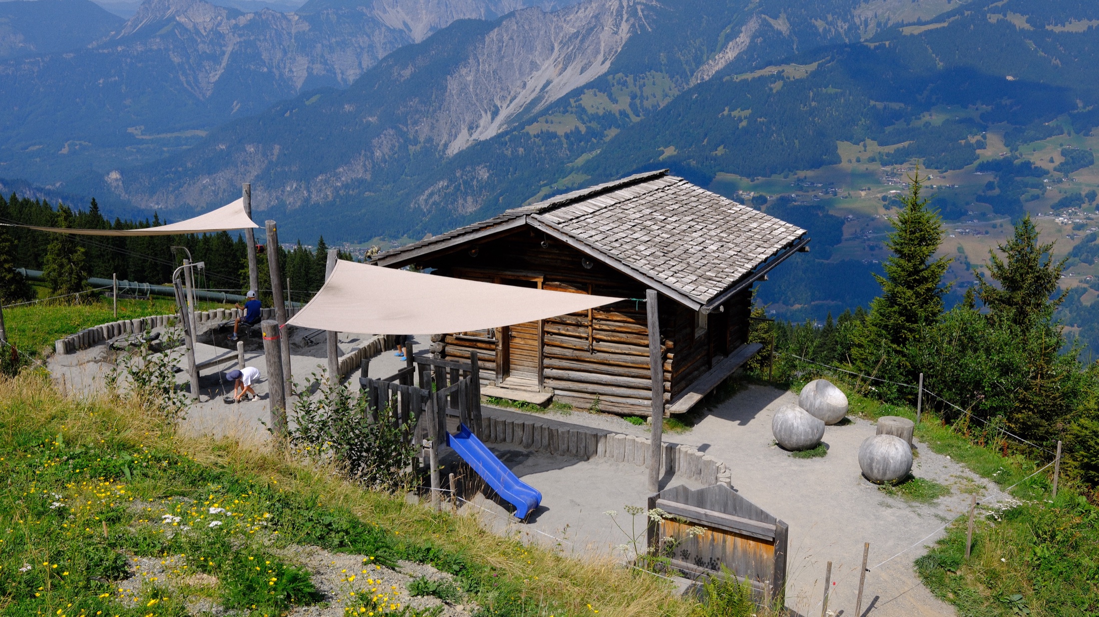 A wooden activity shelter overlooking the Montafon mountains