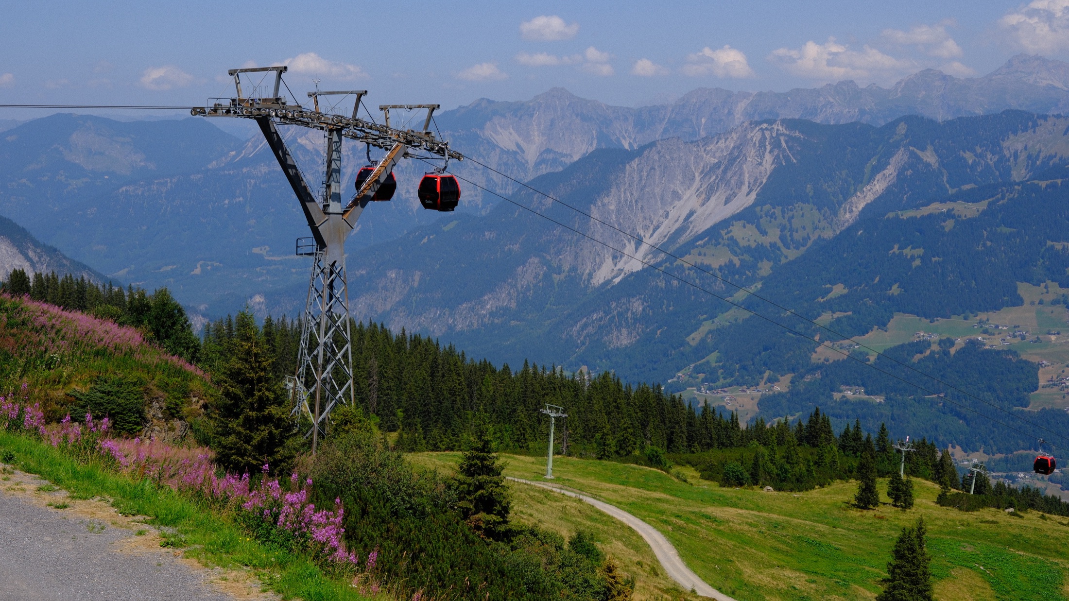 A red Golmerbahn gondola crossing the alpine slope above Montafon