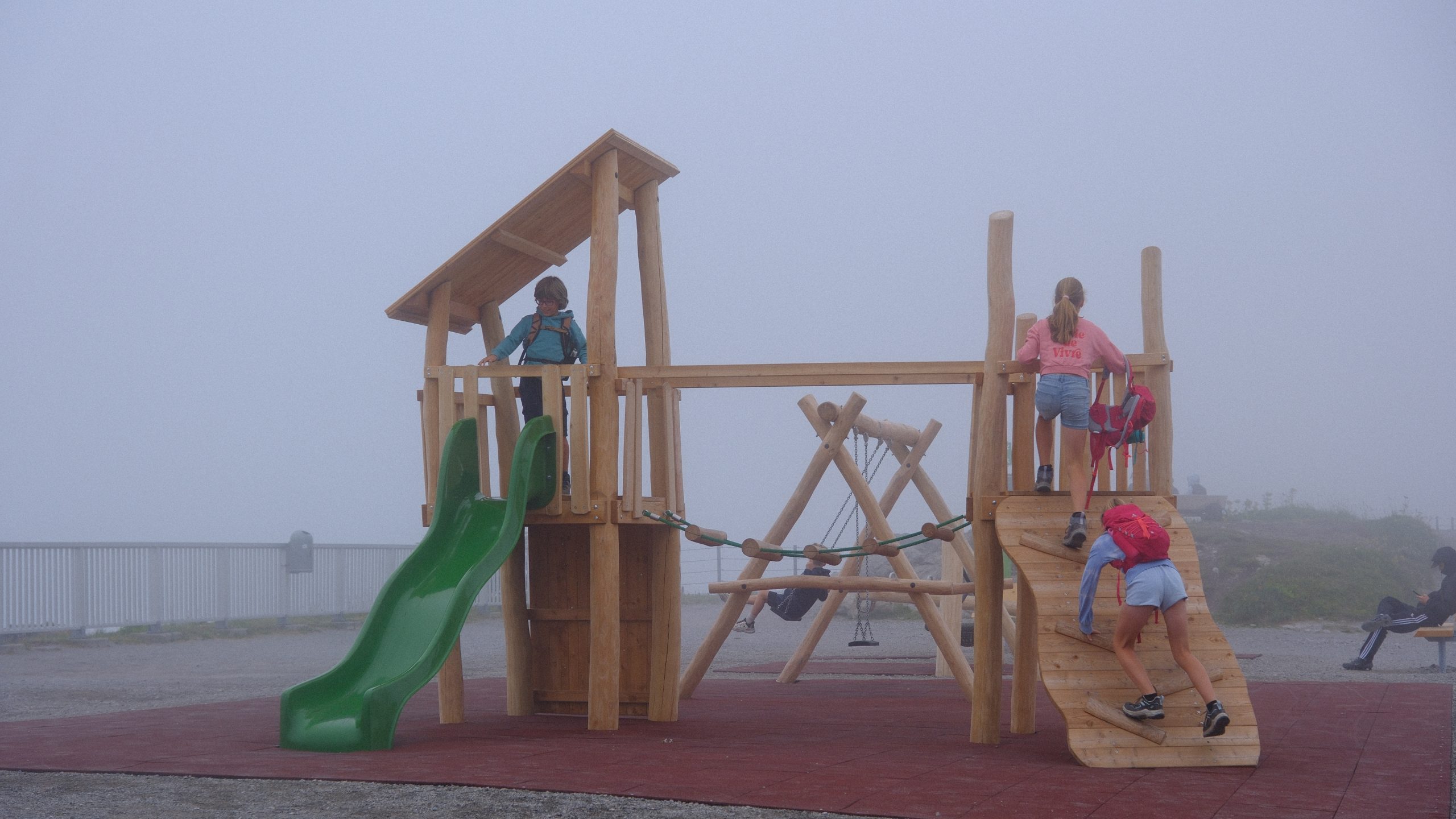 A wooden children's playground almost disappearing in mountain fog beside Lünersee.