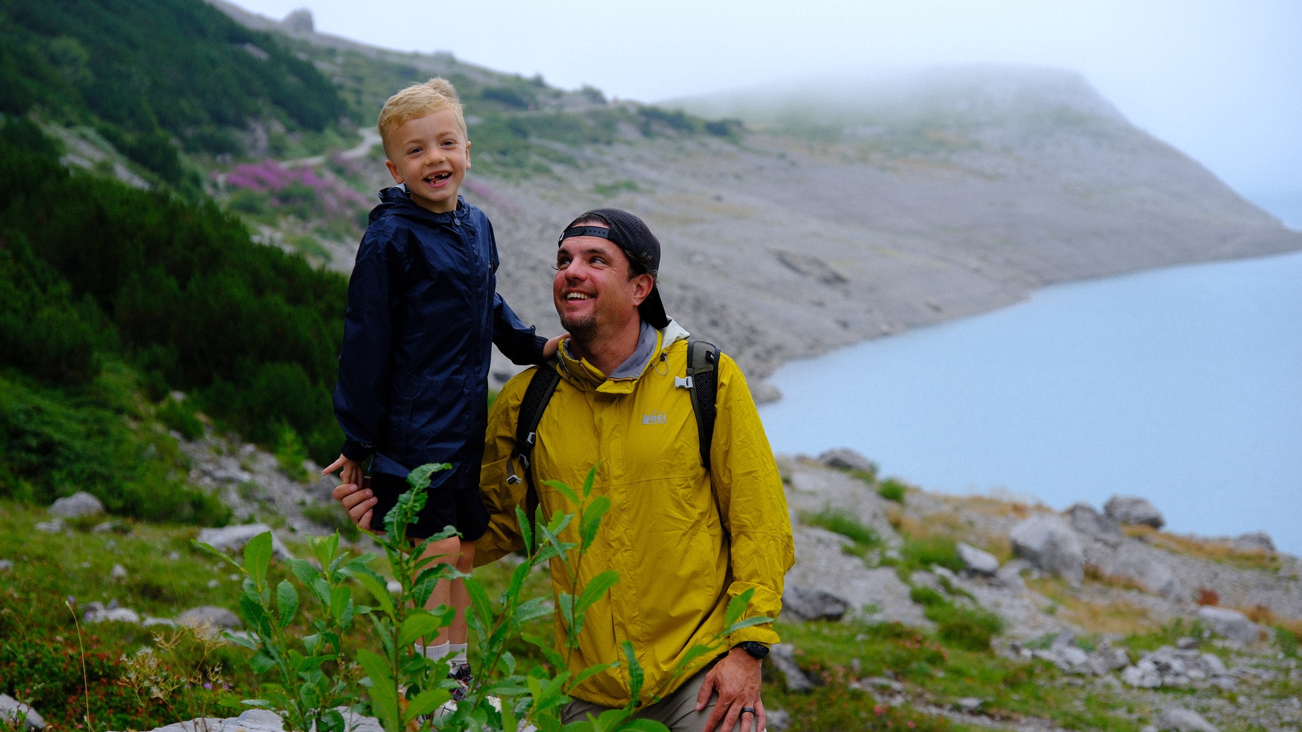 Chris sitting on his father's shoulders with Lünersee behind them.