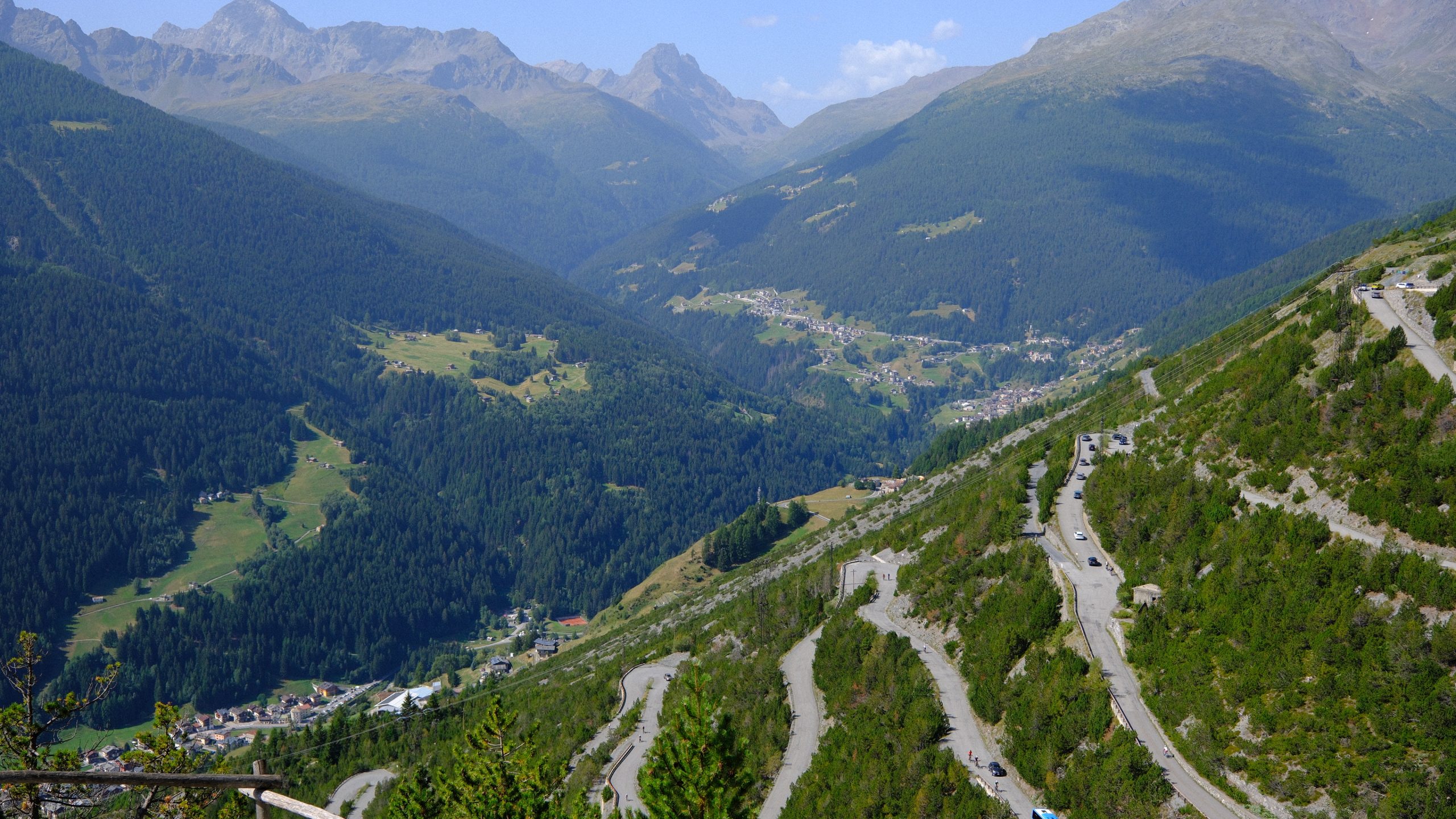 Switchback road descending through the forested Valdidentro valley