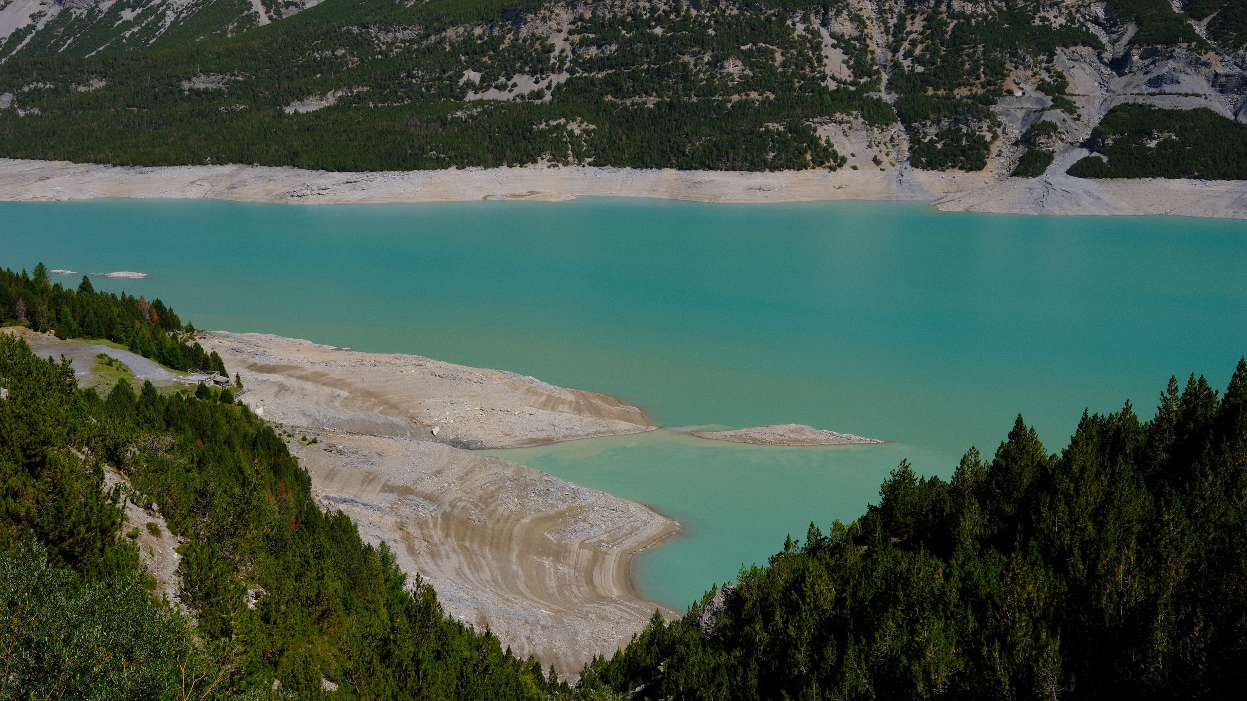 Pale turquoise water and exposed mineral shoreline at Lago di Cancano