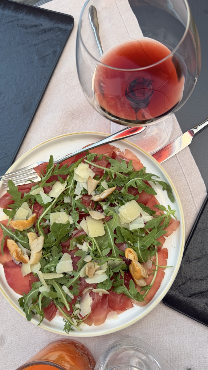 Carpaccio topped with rocket, shaved cheese and mushrooms