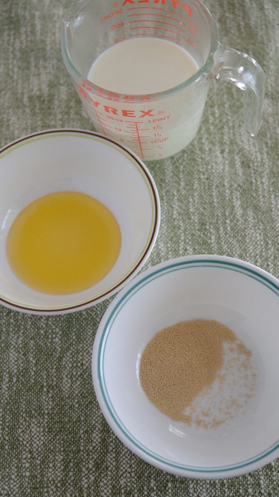Warm milk, honey, and active dry yeast measured for the bread dough