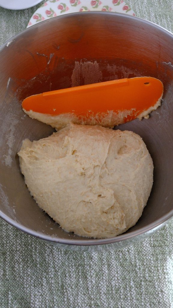 Soft bread dough gathered in a mixing bowl after the first covered rest