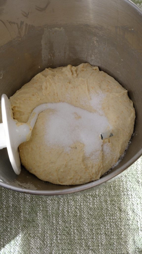 Fine sea salt added to the rested dough in a stand mixer bowl