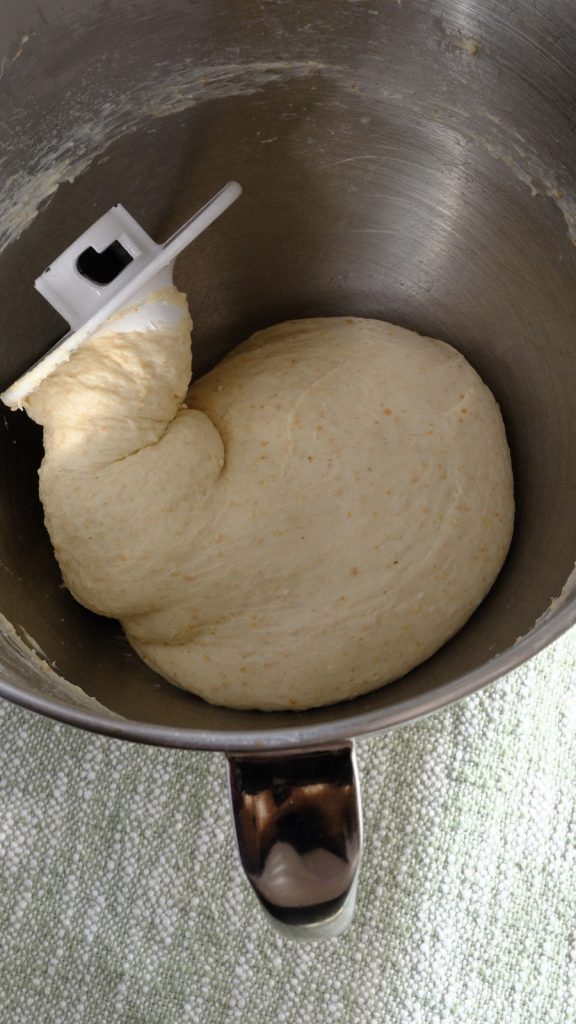 Salted whole wheat and oat bran dough gathered around a hook after the second mixing