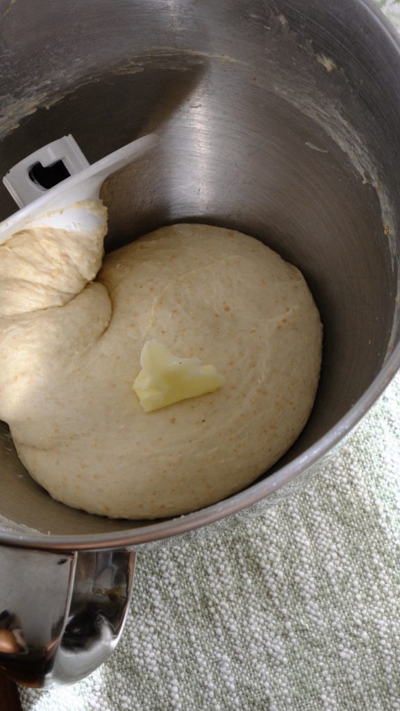 Soft butter placed onto the kneaded bread dough before mixing