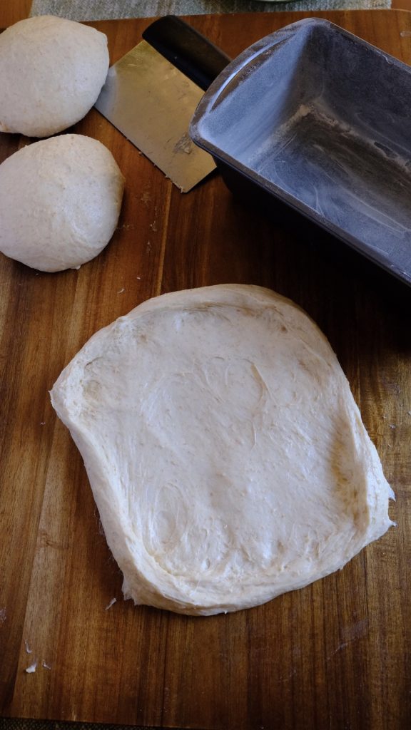 One portion of soft dough flattened into a rectangle for shaping