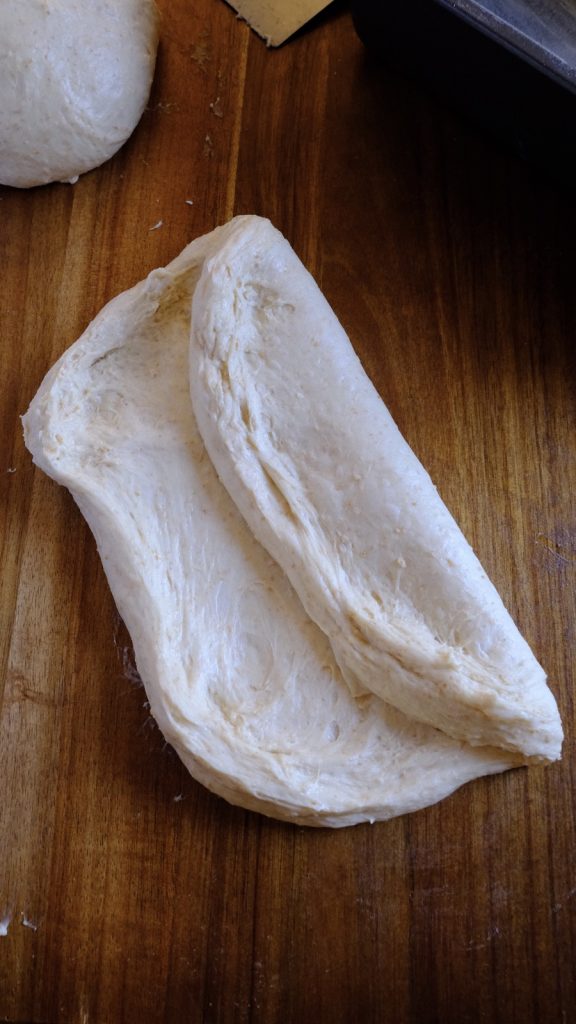 Soft bread dough folded inward like a letter without pressing out all the air