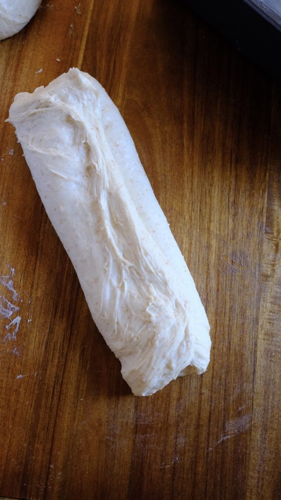 Letter-folded bread dough being gathered gently for final shaping