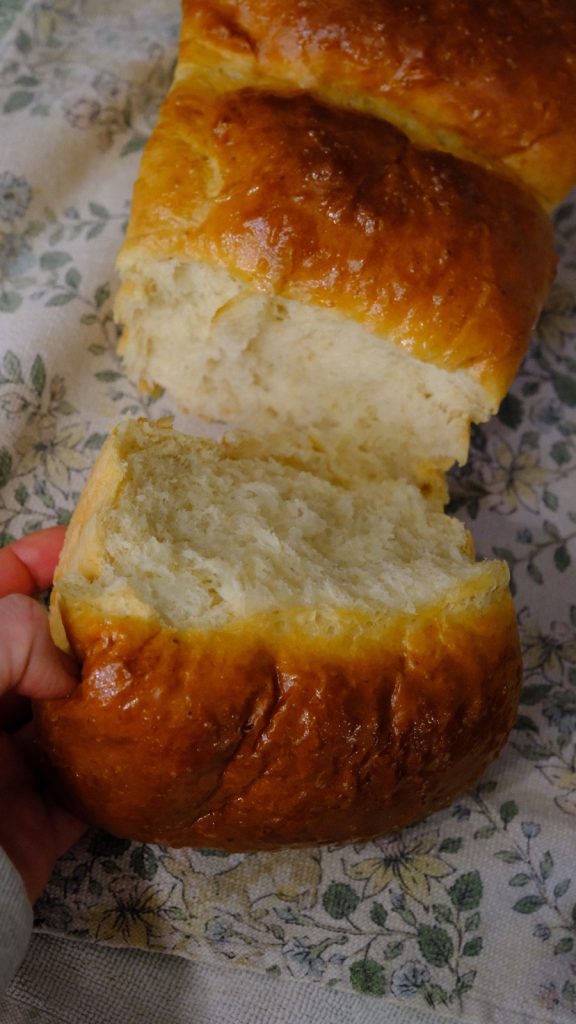 Torn milk bread revealing its moist feathery pull-apart crumb